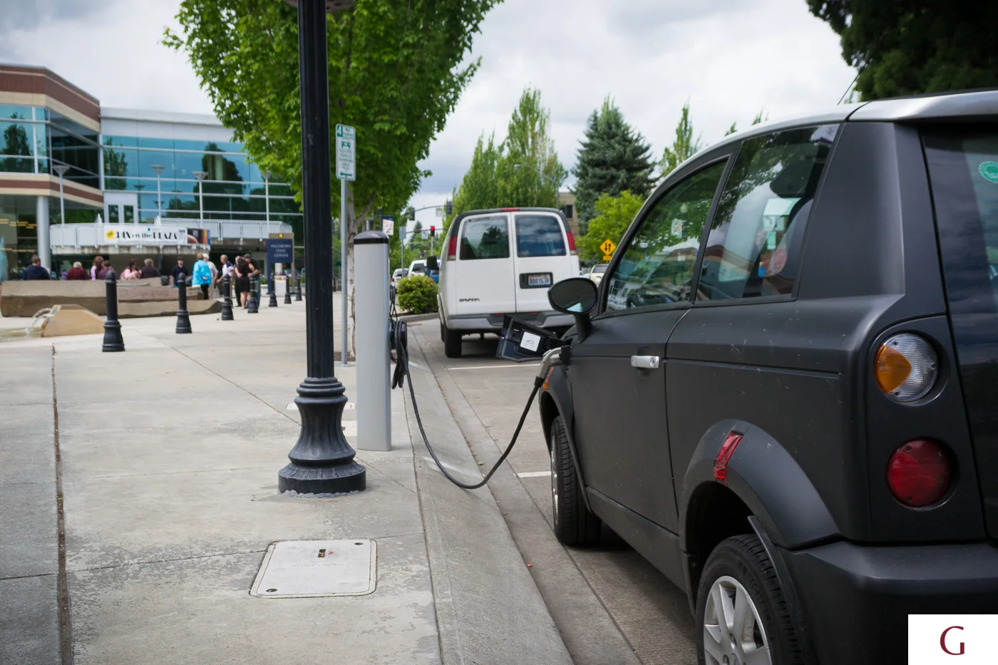Coche eléctrico conectado a un punto de recarga para analizar el consumo en una vivienda turística